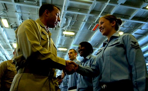 US Navy 061205-N-7130B-056 Capt. Terry Kraft, commanding officer aboard USS Ronald Reagan (CVN 76), congratulates Yeoman 2nd Class Heidi Spoonheim during an advancement ceremony held in the ship's hangar bay