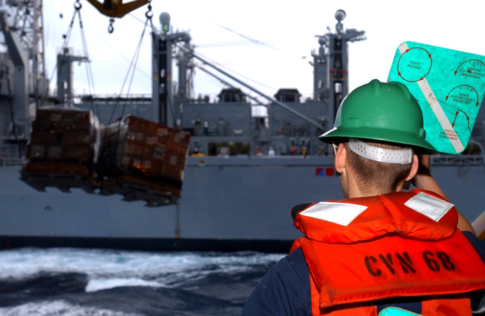 US Navy 061209-N-0890S-004 A Sailor signals personnel from Military Sealift Command (MSC) fast combat support ship USNS Bridge (T-AOE 10) during an underway replenishment (UNREP)