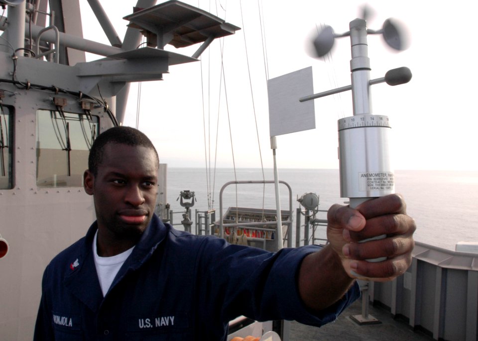 US Navy 061210-N-8547M-001 Aerographer's Mate 3rd Class Akin Akinjoila uses an anemometer to check wind conditions aboard amphibious assault ship USS Saipan (LHA 2)