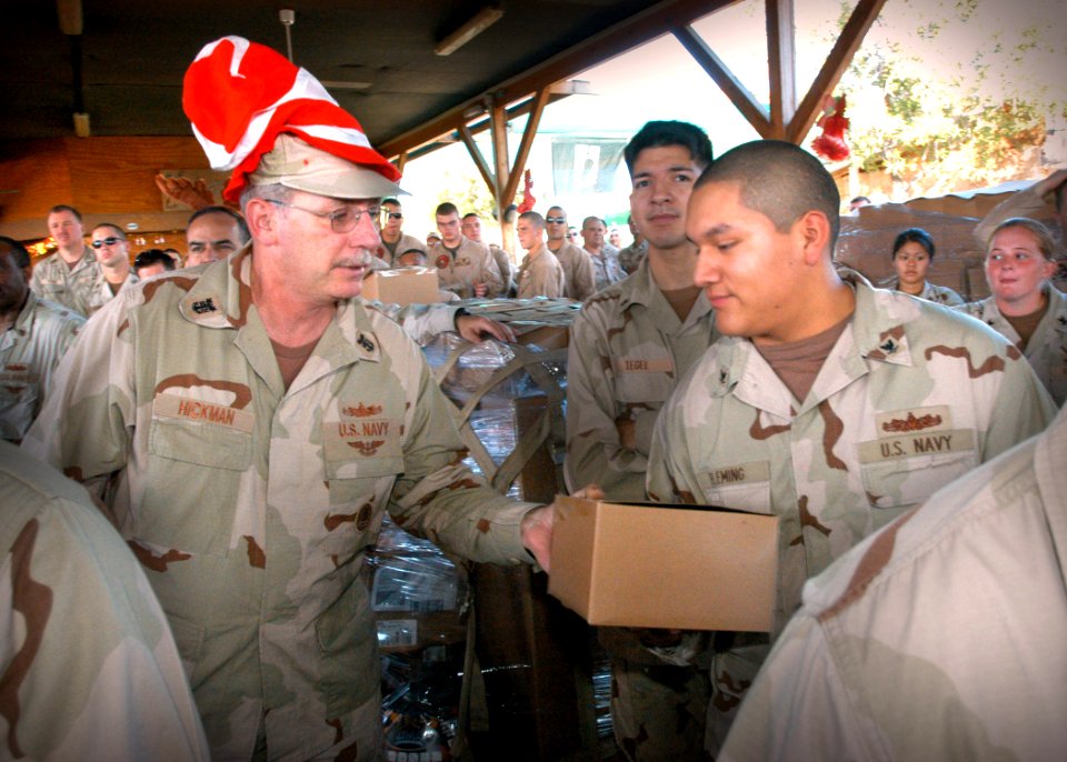 US Navy 061210-N-1328C-080 Morale, Welfare and Recreation (MWR) headquarters Command Master Chief Buck Hickman hands Yeoman 3rd Class David Fleming, of Denver, Colo., a Christmas gift
