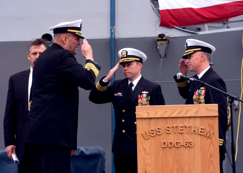 US Navy 061212-N-2716P-015 Cmdr. Robert P. Gonzales (right) and Cmdr. Paul J. Lyons (center) salute Commander Destroyer Squadron Fifteen Capt. Robert P. Girrier after reading their orders