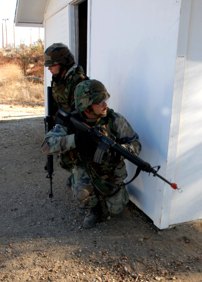 US Navy 061206-N-3560G-022 Equipment Operator 1st Class (SCW) Simon Wyant and Steelworker 3rd Class Jessica Stager of Naval Mobile Construction Battalion Four (NMCB-4) prepare to clear a building of unknown threats during field