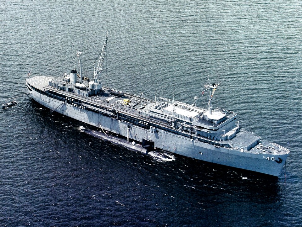 USS Frank Cable (AS-40) at anchor, with a Sturgeon class nuclear-powered submarine alongside, in the 1980s (NH 107771-KN)