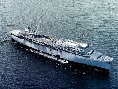 USS Frank Cable (AS-40) at anchor, with a Sturgeon class nuclear-powered submarine alongside, in the 1980s (NH 107771-KN)