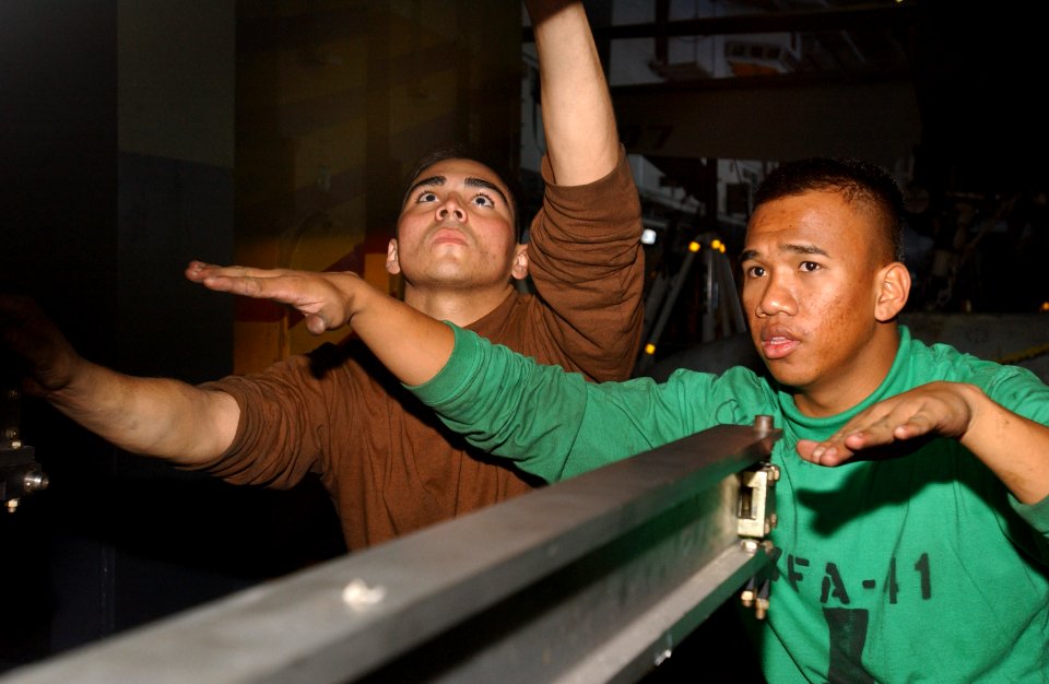 US Navy 061212-N-0890S-015 Aviation Machinist's Mate Airman Dave Carbajao, left, and Aviation Machinist's Mate 3rd Class Patrick Cuaresma assigned to the Black Aces of Strike Fighter Squadron Four One (VFA-41)