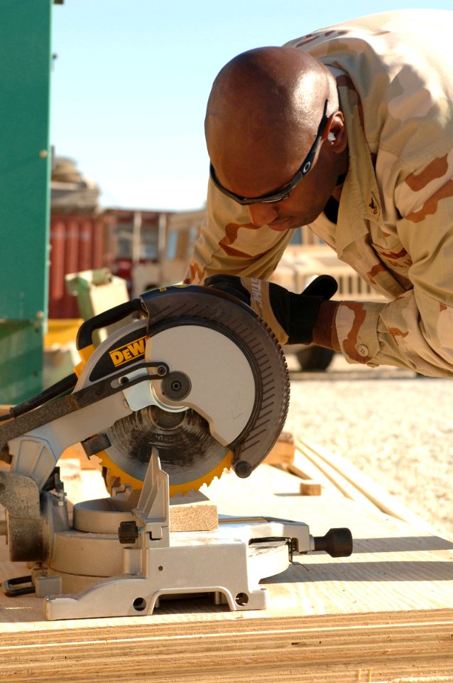 US Navy 061220-N-0193M-003 Boatswain's Mate 2nd Class Antoine Little lines the miter saw up with his pencil marks to ensure he cuts the board to the correct length