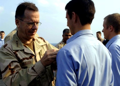 US Navy 061221-N-5330L-245 After answering some questions aboard the guided-missile cruiser USS Anzio (CG 68), Chief of Naval Operations (CNO) Adm. Mike Mullen awards some of Anzio's Sailors their Surface Warfare pins