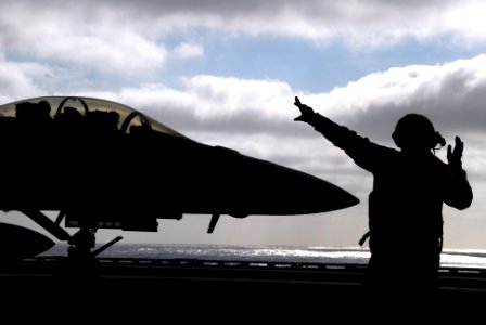US Navy 061215-N-8158F-138 Aviations Boatswain's Mate (Handling) 2nd Class Kevin Sanchez directs an F-A-18E Super Hornet assigned to the Tophatters of Strike Fighter Squadron Four One (VFA-41), after success