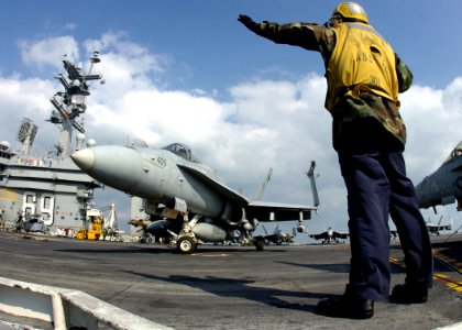 US Navy 061219-N-8907D-001 An aircraft director signals to a F-A-18C Hornet from the Wildcats of Strike Fighter Squadron One Three One (VFA-131) prior to launch aboard the Nimitz-class aircraft carrier USS Dwight D. Eisenhower