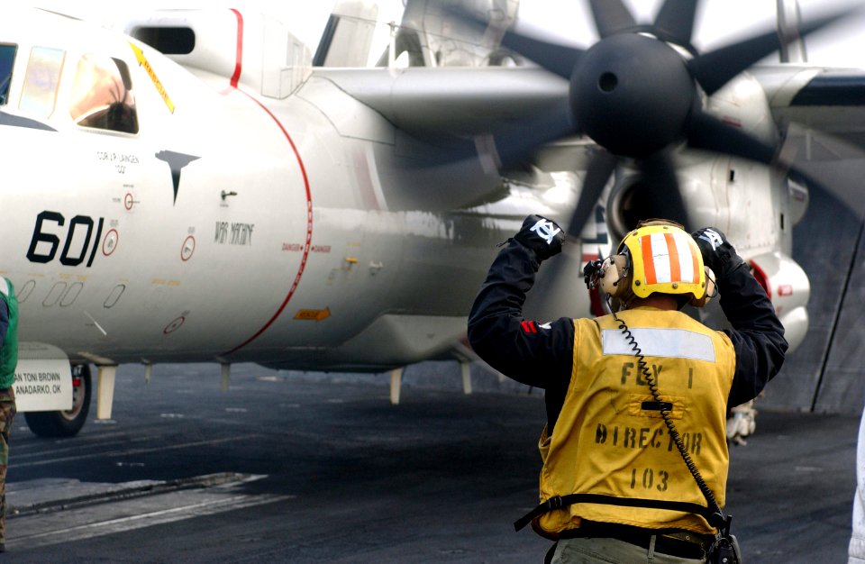 US Navy 061215-N-0890S-024 A crew member directs a C-2A Greyhound assigned to the Providers of Carrier Logistics Support Squadron Three Zero (VRC-30) aboard the nuclear-powered aircraft carrier USS Nimitz (CVN 68)