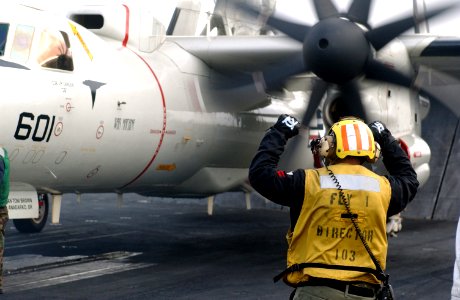 US Navy 061215-N-0890S-024 A crew member directs a C-2A Greyhound assigned to the Providers of Carrier Logistics Support Squadron Three Zero (VRC-30) aboard the nuclear-powered aircraft carrier USS Nimitz (CVN 68)