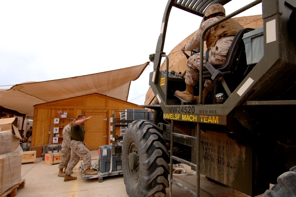 US Navy 061216-N-5758H-262 1st Lt. John Reeves instructs fork lift driver Sgt. James Sanchez, both assigned to Marine Aviation Logistics Squadron (MALS) 16, Supply Detachment A, to bring the forks on the 10k fork lift down whil