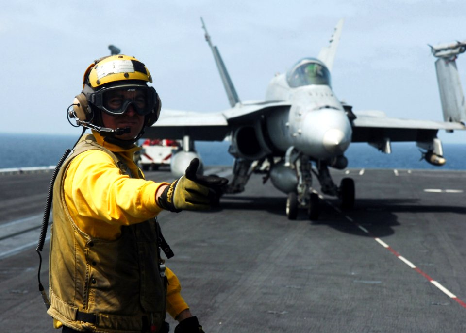 US Navy 070108-N-8907D-001 A plane director relays the pilot to the next director aboard the Nimitz-class aircraft carrier USS Dwight D. Eisenhower (CVN 69)