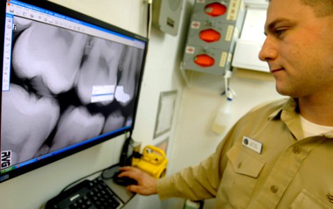 US Navy 061216-N-5345W-018 General dentistry officer Lt. Adam Clock looks over x-rays while taking care of a patient in the dental lab aboard the Nimitz-class aircraft carrier USS Harry S. Truman (CVN 75)