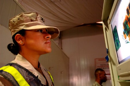 US Navy 061223-N-5758H-148 Boatswain's Mate 2nd Class Evelyn Sellers, assigned to Navy Customs Battalion Romeo, screens troops' luggage being X-rayed prior to their return flight to the U.S. to ensure the bags are contraband fr