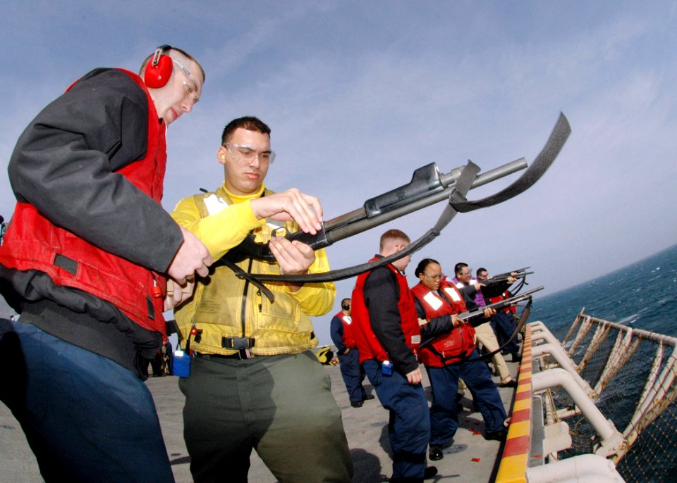 US Navy 070115-N-0209M-004 A Sailor stationed aboard the amphibious assault ship USS Boxer (LHD 4), is shown how to load a shotgun during live-fire training