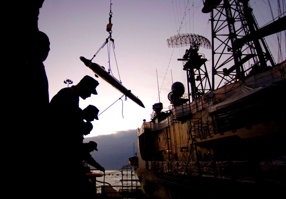 US Navy 070105-N-9769P-152 Southwest Regional Maintenance Center (SWRMC) topside divers attend to divers in the water while a 13-ton stabilizer fin is hoisted from the Oliver Hazard Perry-class frigate USS McCluskey (FFG 41)