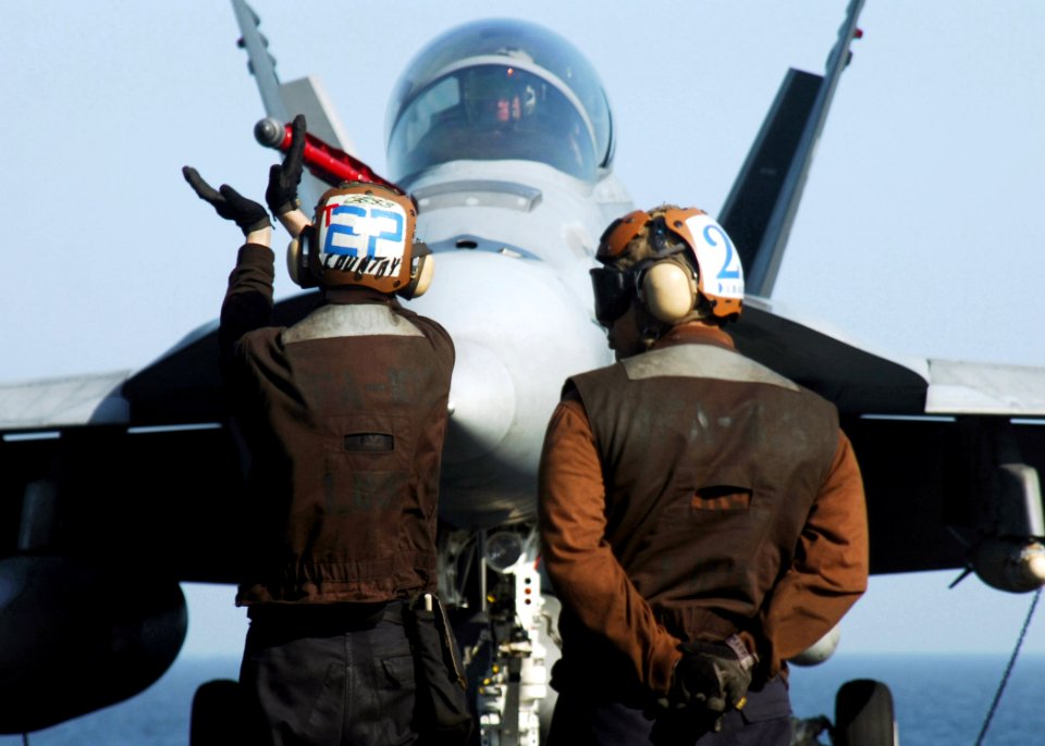 US Navy 070108-N-8907D-005 A plane captain signals the pilot to check the flaps of an F-A-18F Super Hornet assigned to the Jolly Rogers of Strike Fighter Squadron One Zero Three (VFA-103) aboard the Nimitz-class a
