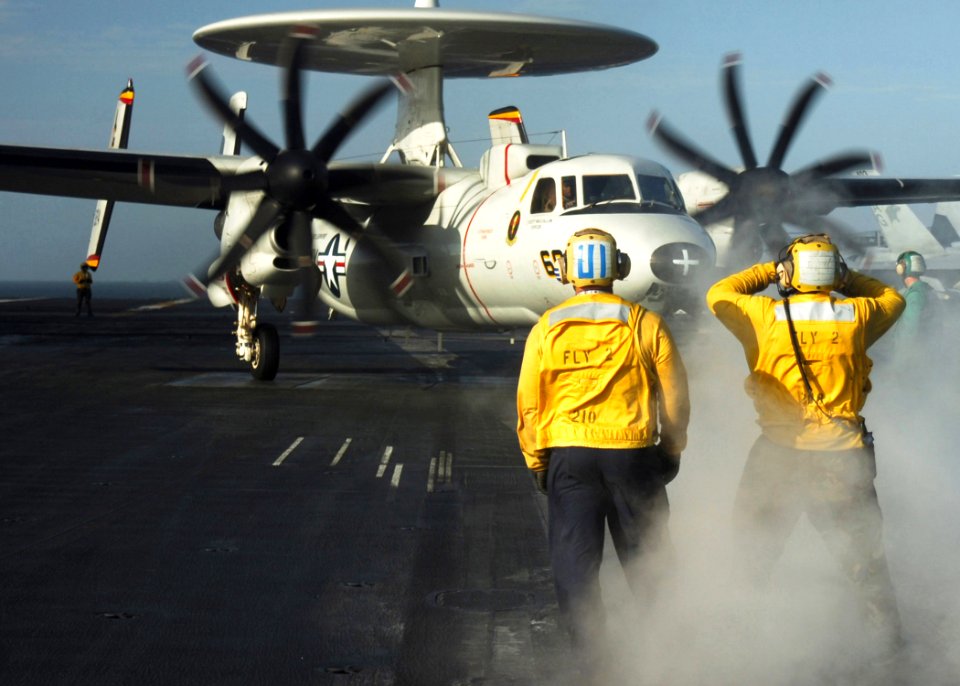 US Navy 070108-N-8907D-006 A plane director moves an E-2C Hawkeye assigned to the Tigertails of Carrier Airborne Early Warning Squadron One Two Five (VAW-125) into launch position aboard the Nimitz-class aircraft carrier USS Dw