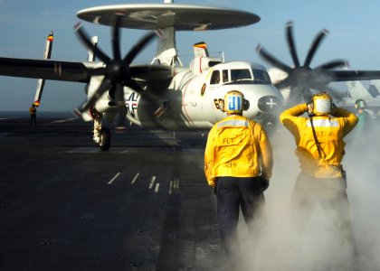 US Navy 070108-N-8907D-006 A plane director moves an E-2C Hawkeye assigned to the Tigertails of Carrier Airborne Early Warning Squadron One Two Five (VAW-125) into launch position aboard the Nimitz-class aircraft carrier USS Dw