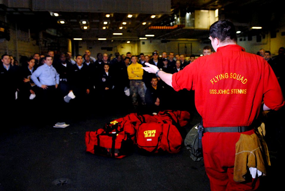 US Navy 070117-N-0684R-006 Damage Controlman 2nd Class Timothy Roney teaches new Sailors about fire fighting equipment aboard the Nimitz-Class aircraft carrier USS John C. Stennis (CVN 74)