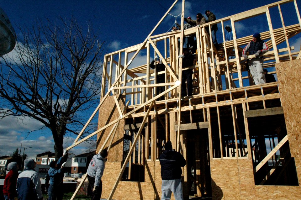 US Navy 070117-N-2456S-153 Sailors from amphibious transport dock USS Nashville (LPD 13) raise a roof truss onto the top of the house they are building for Habitat for Humanity in Norfolk, Va