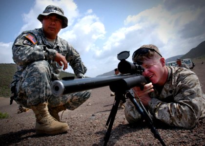 US Navy 061223-N-1328C-509 Army Sgt. Mijung Kim, left, from Harmon, Guam, observes Marine Corps Sgt. John Rheuby, from Hueytown, Ala., as Rheuby fires an M-24 rifle during a familiarization shoot