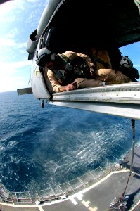 US Navy 070115-N-0490C-010 Aviation Warfare Systems Operator 1st Class Wade Hove assigned to the Dragon Whalers of Helicopter Sea Combat Squadron Two Eight (HSC-28) ensures the deck is clear before dropping supplies