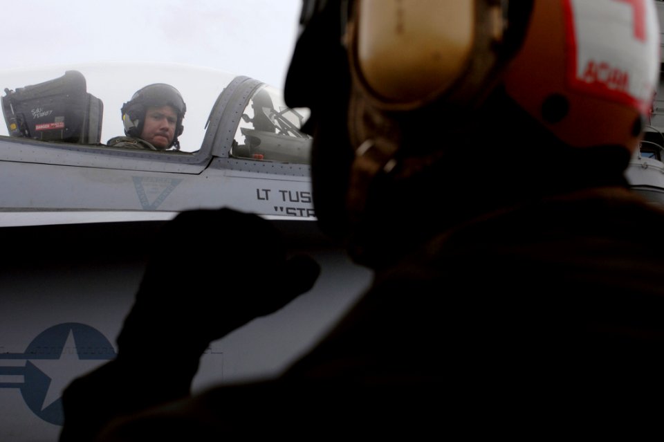 US Navy 070121-N-5345W-015 A naval aviator assigned to the Golden Warriors of Strike Fighter Squadron Eight Seven (VFA-87) watches his plane captain while conducting pre-flight checks on his F-A-18C Hornet during flight operati