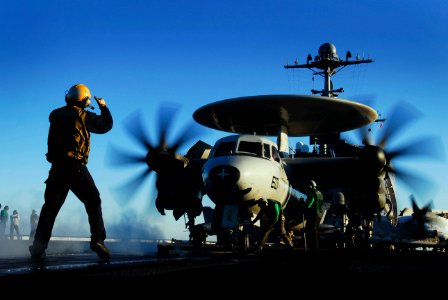 US Navy 070122-N-3729H-109 An aircraft flight deck director guides an E-2C Hawkeye assigned to the Golden Hawks of Carrier Airborne Early Warning Squadron One One Two (VAW-112) onto a steam propelled catapult for launch