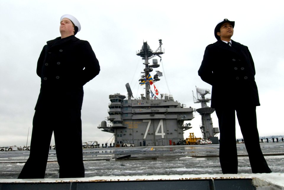 US Navy 070116-N-3729H-008 Information Systems Technician 2nd Class Lyna Tuon and Information Systems Technician 2nd Class Dwight Harding man the rails as USS John C. Stennis (CVN 74) departs Naval Base Kitsap Bremerton