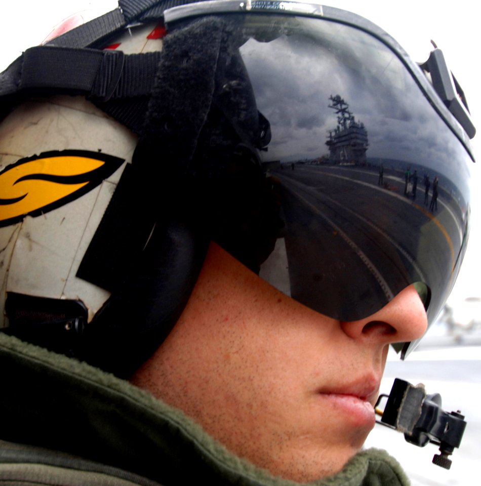 US Navy 070116-N-0535P-039 Aviation Warfare Systems Operator 2nd Class David Musser, attached to the Red Lions of Helicopter Anti-Submarine Squadron One Five (HS-15), looks out the door of an SH-60 Seahawk while a