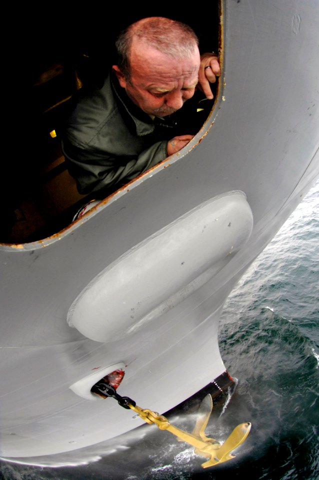 US Navy 070122-N-5345W-055 Senior Chief Boatswain's Mate Hobart Allen watches from a forecastle porthole as the starboard anchor is cleaned and raised after a precision anchoring exercise aboard the Nimitz-class aircraft carrie