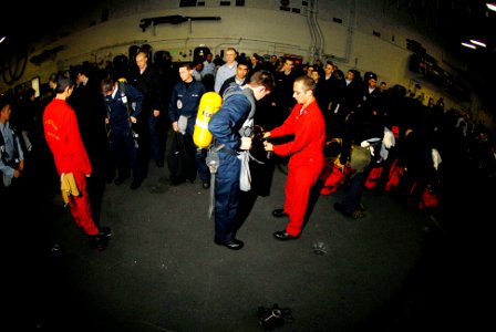 US Navy 070117-N-0684R-025 Damage Controlman 2nd Class Joshua Soderberg instructs new Sailors on the proper technique for donning a self-contained breathing apparatus (SCBA) aboard the Nimitz-Class aircraft carrier USS John C