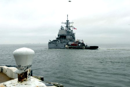 US Navy 070105-N-5459S-003 A tugboat assist the guided missile cruiser USS Vella Gulf (CG 72) as the ship deploys from Naval Station Norfolk photo