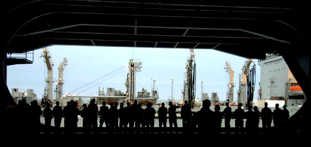 US Navy 070116-N-8923M-003 Sailors watch from the hangar bay of Nimitz-class aircraft carrier USS Harry S. Truman (CVN 75) as the Military Sealift Command supply ship USNS Patuxent (T-AO 201) pulls alongside during morning prep