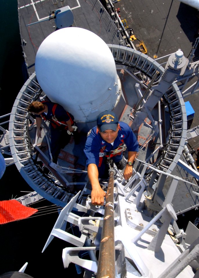 US Navy 070124-N-4965F-004 Electronics Technician 2nd Class Joseph Melchor, assigned to the Arleigh Burke-class guided-missile destroyer USS Paul Hamilton (DDG 60), climbs the mast of the Paul Hamilton to perform pre-deployment