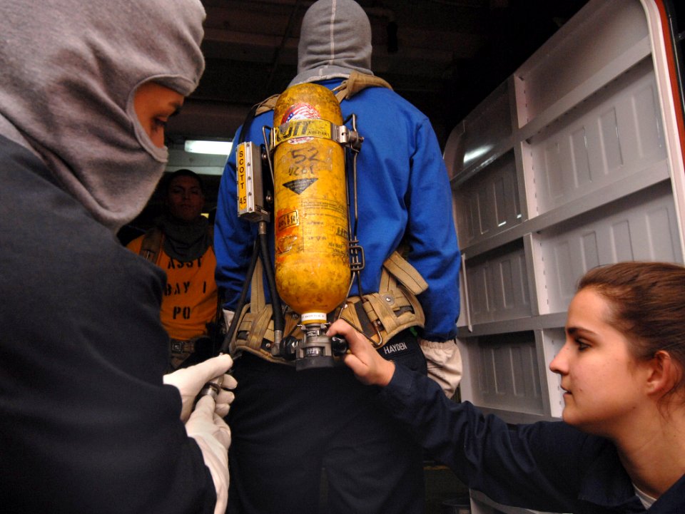 US Navy 070117-N-8923M-067 A fire team member gets his Self-Contained Breathing Apparatus (SCBA) checked before joining the rest of his team during a general quarters drill aboard the Nimitz-class aircraft carrier USS Harry S