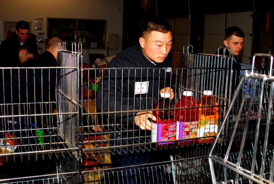 US Navy 070117-N-1831S-025 Storekeeper 3rd Class Young Kim, assigned aboard the amphibious transport dock USS Nashville (LPD 13), stocks a cart with food items at the South Eastern Hampton Roads Food Bank