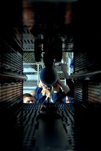 US Navy 070125-N-0684R-095 Fire controlmen assigned to combat systems department work as a team to load AIM-7 Sea Sparrow Air Intercept Missiles into a battery chamber aboard the Nimitz-class aircraft carrier USS John C. Stenni