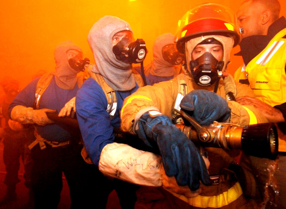 US Navy 070117-N-5345W-082 A fire team nozzleman is relieved after expending the oxygen supply in his Self-Contained Breathing Apparatus (SCBA) while fighting a simulated hangar bay fire during a general quarters drill
