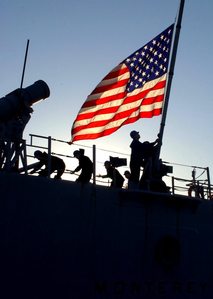 US Navy 070115-N-0780F-005 A Sailor hoists the national ensign as Sailors aboard guided missile cruiser USS Monterey (CG 61) conduct mooring operations upon their arrival at the Marathi NATO Pier Facility