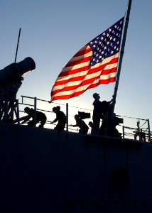 US Navy 070115-N-0780F-005 A Sailor hoists the national ensign as Sailors aboard guided missile cruiser USS Monterey (CG 61) conduct mooring operations upon their arrival at the Marathi NATO Pier Facility