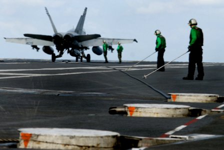 US Navy 070121-N-0684R-115 Flight deck personnel from air department prepare to guide an arresting gear cable back to its housing after an F-A-18C Hornet attached to the Argonauts of Fighter Squadron One Four Seven (VFA-147) s