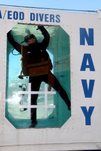 US Navy 070127-N-0318S-001 Master Diver Kyle Gaillard assigned to the Naval Special Warfare Center Panama gathers parade beads in the Explosive Ordnance Disposal (EOD) dive tank to give to people who come up to the dive tank an