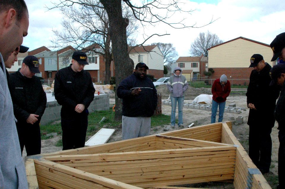 US Navy 070117-N-2456S-002 Antonio Burke, pastor for the Center of Love Church of God in Christ (COGIC), leads Sailors from amphibious transport dock USS Nashville (LPD 13) in a prayer before building a house for Habitat for Hu