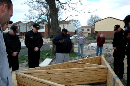 US Navy 070117-N-2456S-002 Antonio Burke, pastor for the Center of Love Church of God in Christ (COGIC), leads Sailors from amphibious transport dock USS Nashville (LPD 13) in a prayer before building a house for Habitat for Hu