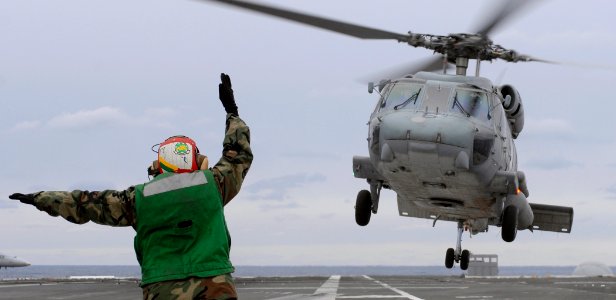 US Navy 070121-N-5345W-017 A landing signal enlistedman (LSE) directs an SH-60F Seahawk assigned to the Tridents of Helicopter Anti-Submarine Squadron Three (HS-3) toward the flight deck of Nimitz-class aircraft carrier USS Har