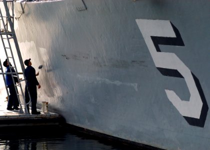 US Navy 070123-N-5253W-024 Sailors aboard the Avenger-class mine hunter USS Guardian (MCM 5) paint the hull while in port at Commander Fleet Activities Yokosuka during the ship's visit from it's home port of Sasebo, Japan