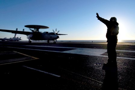 US Navy 070122-N-3729H-186 An aircraft flight deck director guides an E-2C Hawkeye assigned to the Golden Hawks of Carrier Airborne Early Warning Squadron One One Two (VAW-112) out of the landing area
